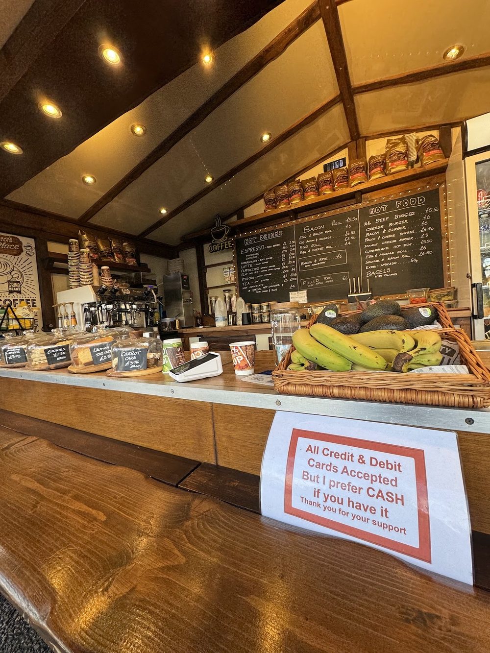 Inside the serving hatch: coffee kit, trays of pastries and bananas on the counter